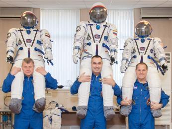 At the Baikonur Cosmodrome in Kazakhstan, the Expedition 33 crew share a playful moment Oct. 10, 2012 during the first of two so-called “fit check” dress rehearsal sessions.