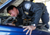 A CBP officer closely inspects a vehicle's engine compartment during a search at the DeConcini port of entry in Nogales, Ariz.