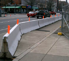 Photo of temporary pedestrian route in street, protected by barriers.