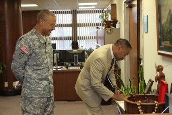 HONOLULU -- Dr. Jonathan Woodson, Assistant Secretary of Defense for Health Affairs and Director, Tricare Management Activity, signs the Pacific Regional Medical Command and Tripler Army Medical Center's guest book, Oct. 9, at TAMC. Woodson is touring the U.S. Pacific Command area of responsibility and received multiple briefs from staff at Tripler. He wants to ensure he understands the needs of the beneficiaries in the Pacific and that their needs are being met.