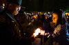 A Border Patrol agent assists Mrs. Dittman to light her candle during last night’s vigil. Mrs. Dittman's husband was killed in the line of duty while working as a Border Patrol agent.