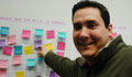 Close-up of Alejandro Zapata Arango pointing at board of Post-It notes (Courtesy of Alejandro Zapata Arango)