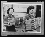 two women carrying bundles