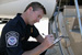 A CBP Officer verifies Proper documentation on a small commercial aircraft.