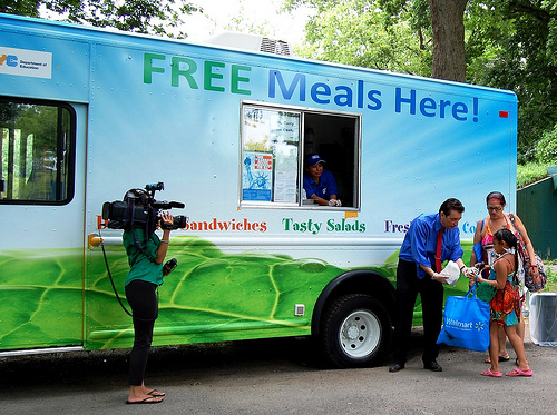 Northeast Regional Administrator, James Arena-DeRosa serves a meal from the NYC food truck at Orchard Beach in the Bronx.