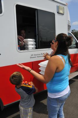 LaPlace, La., Sep. 5, 2012 -- A family of Hurricane Isaac survivors from LaPlace, La. grab a meal from the Red Cross at a distribution center. This group of volunteers came from Houston to help those affected by Hurricane Isaac.