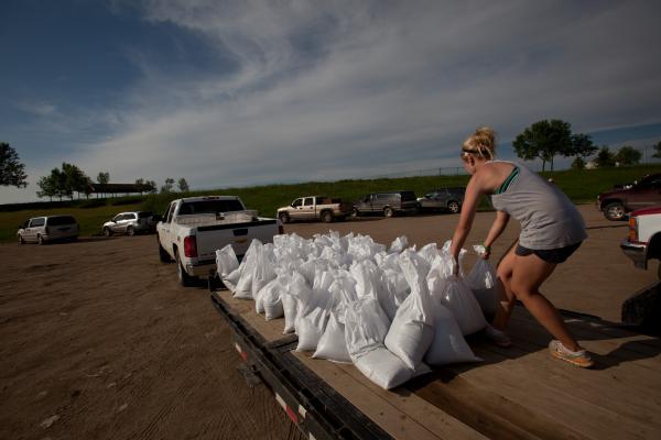  Liva Rovig loads sandbags on the back of a flatbed trailer at the Sertoma Sports Complex. Residents are sandbagging along the Souris River to try to prevent flooding.
