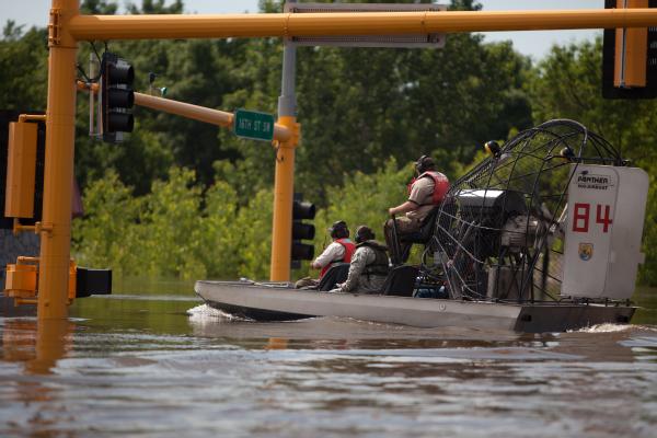 National Guardsman, and U.S. Deptartment of Wildlfe Services travel by airboat through flooded Oak Park neighborhood in Minot, N.D. The team were on a reconnaissance mission to check on telephone/power stations. 