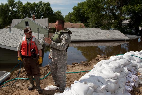 Officials from the National Guard and U.S. Fish and Wildlife Service discuss flood fighting measures during a survey of the damaged area.