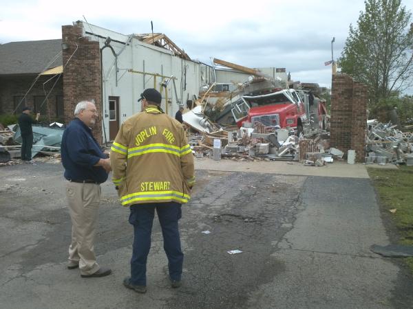Administrator Craig Fugate surveys a damaged fire station with a Joplin firefighter.