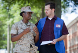 Red Cross man delivering an emergency communication to a military service woman