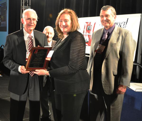 Orlando, Fla., March 27, 2012 -- Mary Hudak, FEMA's Region IV External Affairs Director, is presented with the Distinguished Service Award from Former Director of the National Hurricane Center Max Mayfield (left), and current Director of the National Hurricane Center Bill Reed (right) at the 2012 National Hurricane Conference held in Orlando, Fla.