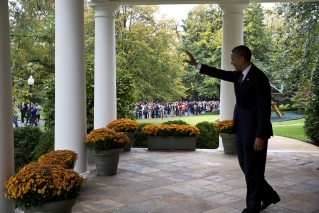 President Barack Obama waves from the Colonnade to visitors as they tour the White House grounds and gardens, Oct. 19, 2012. Members of the public were invited to tour the grounds as part of the 2012 White House Fall Garden Tours. (Official White House Photo by Pete Souza)