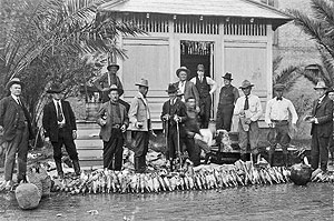 In the back yard of the Custom House in Brownsville, Texas – U.S. Customs Mounted Inspectors empty confiscated liquor during the heyday of Prohibition. 