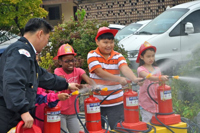 Seoul American Elementary school students learn how to use a fire extinguisher, Oct. 10. (U.S. Army photo by Cpl. Lee Hyokang)