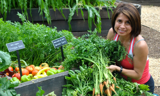 USDA Executive Master Gardener Dora Flores poses proudly with the HQ People's Garden weekly harvest, which she helped grow and pick.