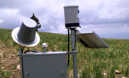 This precipitation gage with solar panel, radio stand, and electronic is part of the Early Warning Detection System installed at the site of the Whitewater Baldy Complex Fire.