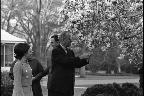 President Lyndon B. Johnson picks a flower for Olympic figure skater Peggy Fleming