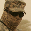 Soldier in goggles and camouflage fabric face covering in the desert