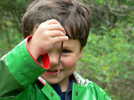 Young boy investigating an earthworm