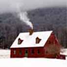 image of snow-covered red house with chimney smoke