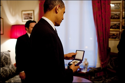 President Barack Obama looks at the Nobel Peace Prize medal for the first time