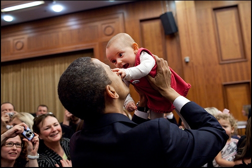 President Obama lifts up a baby during the U.S. Embassy greeting