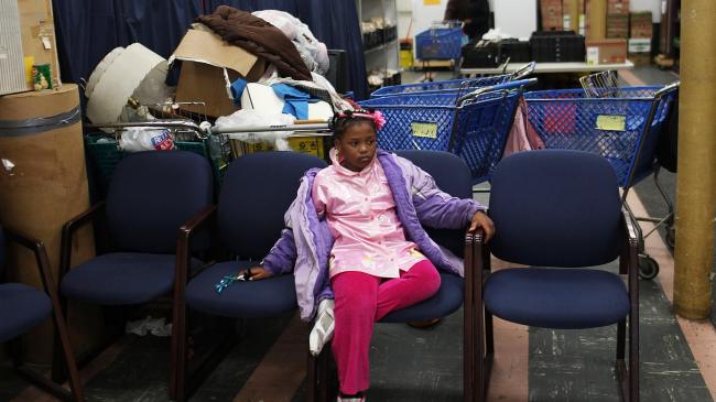 A girl waits for her mother at a food bank on May 15, 2012 in Utica, New York. Like many upstate New York communities, Utica is struggling to make the transition from a former manufacturing hub. (Photo by Spencer Platt/Getty Images)