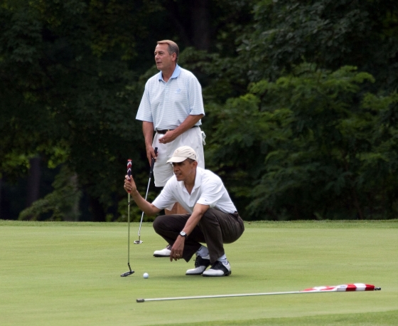 President Barack Obama lines up his putt as he plays a round of golf with House Speaker John Boehner