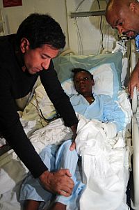 Dr. Sanjay Gupta examines an injured Haitian girl in the medical facility  aboard USS Carl Vinson (CVN 70).