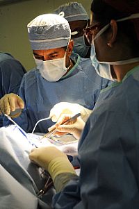 Surgeons perform surgery on a 12-year-old Haitian girl with a severe head injury aboard the Nimitz-class aircraft carrier USS Carl Vinson (CVN 70).