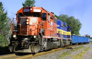 Photo of a train from the front on a track. Shows four train cars behind front of the train.