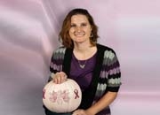 Paula Nordin holds a pink pumpkin in support of Breast Cancer Awareness Month.