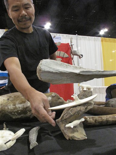 Alaska Native artist Franklin Matchian shows artwork by him and others Thursday, Oct. 18, 2012, at the annual convention of the Alaska Federation of Natives in Anchorage, Alaska. Several thousand Alaska Natives from around the state are expected to attend the three-day event. (AP Photo/Rachel D'Oro)