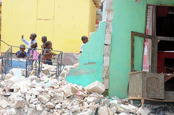 Damaged house and new transitional shelter built following the 2010 earthquake in Port-au-Prince, Haiti.