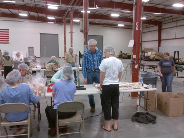 Photo: Packaging food at the SWIPE Out Hunger event with Boy Scout Troop 75 and their families.
