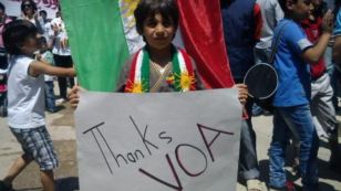 A Syrian Kurdish child at a protest rally holds a poster thanking Voice of America’s Kurdish Service for its coverage of the uprising in Syria.  VOA recently began broadcasting its radio programs on direct to home satellite TV.