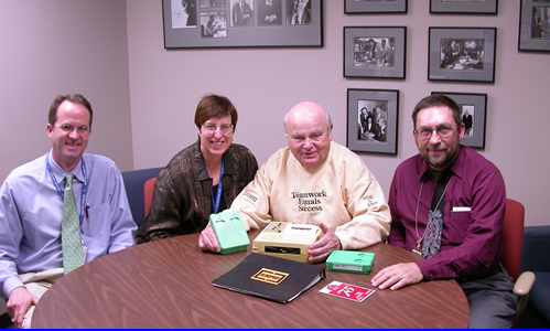 Photo of Frank Kurt Cylke, Robert Norton, Margaret Goergen-Rood, and Robert Mainhart with the 1.5 millionth CBM.