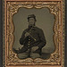 [Unidentified soldier in Union uniform with fife in front of painted backdrop showing a pastoral landscape] (LOC)