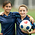 Photo of preteen girls holding a soccer ball.