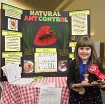 Photo: girl before her "Natural Ant Control" display board.