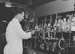 Photo: man in lab coat using laboratory equipment. 
