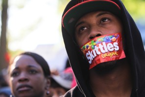 ATLANTA, GA - MARCH 26:  College student Jajuan Kelley covers his mouth with a Skittles wrapper as he stands in a crowd of thousands rallying at the Georgia State Capitol in memory of slain Florida teenager Trayvon Martin on March 26, 2012 in Atlanta, Georgia.  Protests have been nationwide in reaction to the death of Trayvon Martin, the Florida teenager whose shooting by a neighborhood watch captain has led to questions of the 'Stand Your Ground' law in Florida and other states.  (Photo by Jessica McGowan/Getty Images)