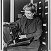 [Frances Benjamin Johnston, three-quarter length portrait, holding and looking down at camera, facing slightly left] (LOC)