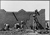 Spanish-American women replastering an adobe house. This is done once a year. Chamisal, New Mexico (LOC) by The Library of Congress