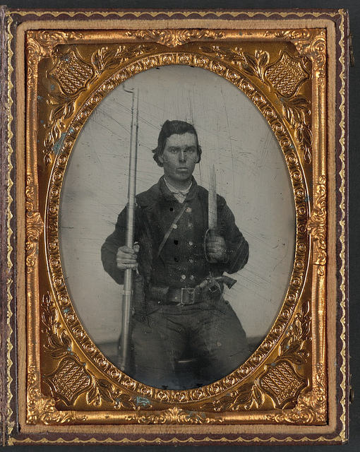 [Unidentified soldier in Confederate uniform with D-guard Bowie knife, musket, and revolver] (LOC)