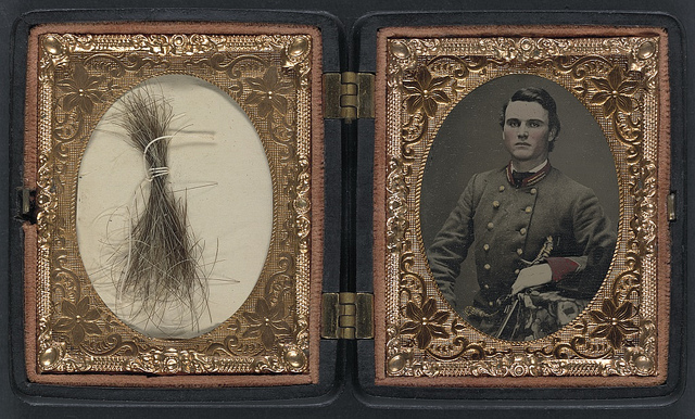 [Unidentified soldier in Confederate artillery first lieutenant's uniform holding sword, with lock of hair in case] (LOC)