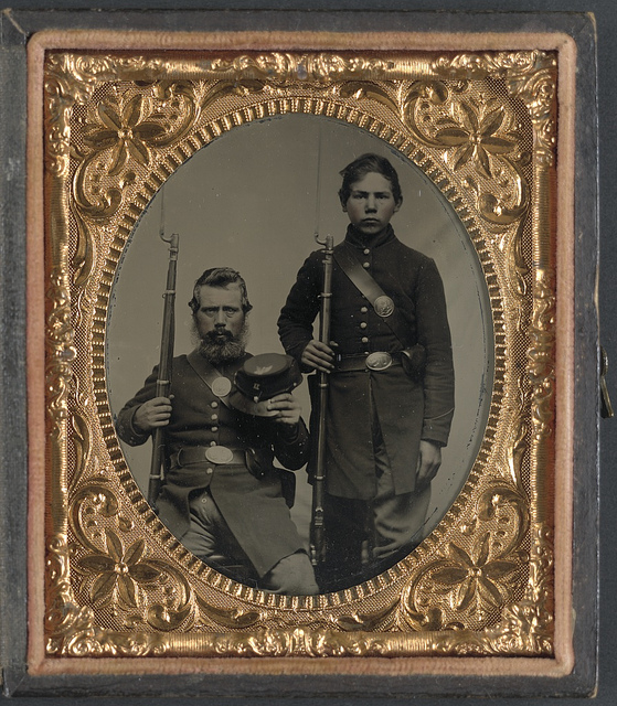 [Two unidentified soldiers, possibly father and son, in Union uniforms and U.S. belt buckles with bayoneted muskets] (LOC)