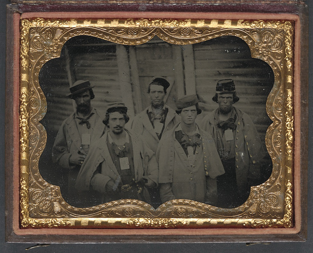 [Five unidentified prisoners of war in Confederate uniforms in front of their barracks at Camp Douglas Prison, Chicago, Illinois] (LOC)