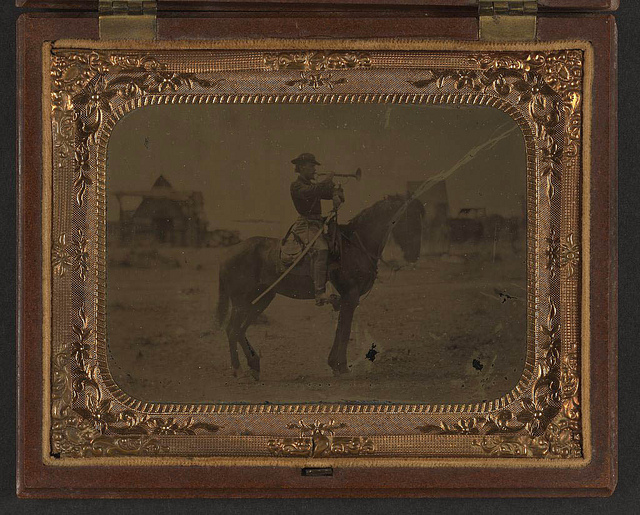 [Unidentified soldier in Union uniform atop horse blowing bugle while unsheathing sword] (LOC)